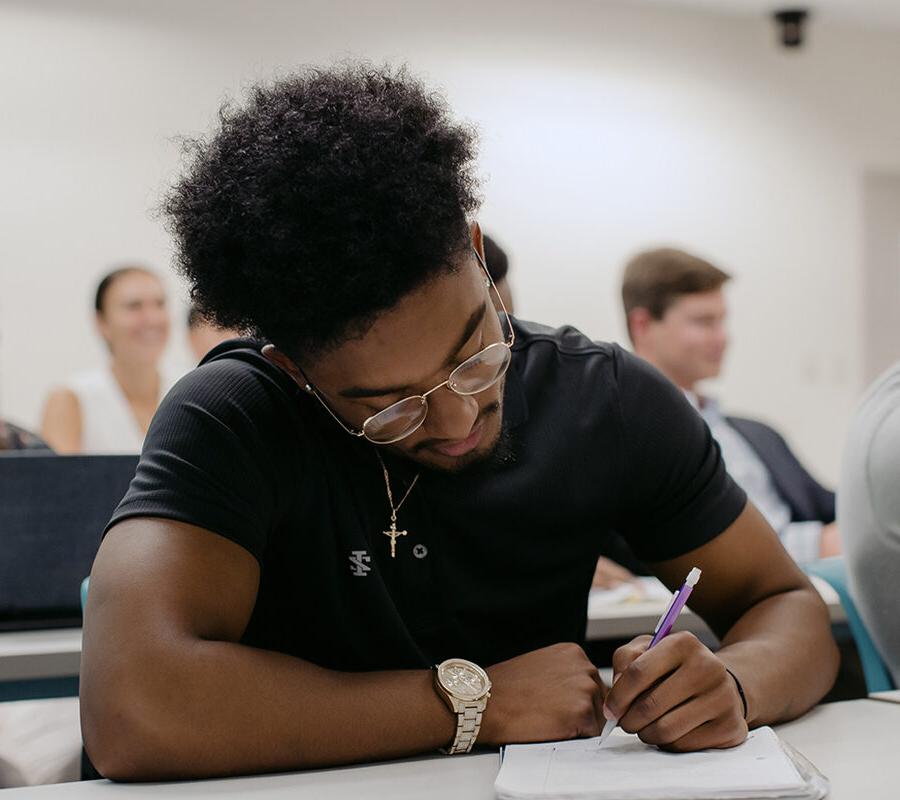 PBA student takes notes in class.